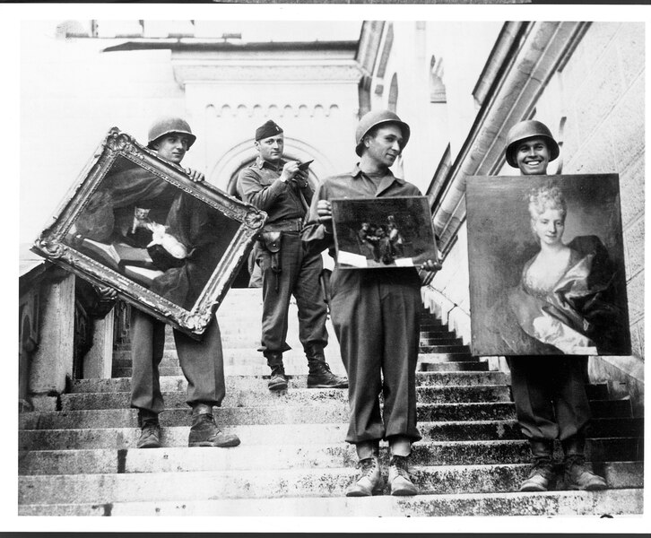 “Monuments Man” James Rorimer, with notepad, supervises U.S. soldiers as they carry paintings down the steps of the castle in Neuschwanstein, Germany, in May 1945.