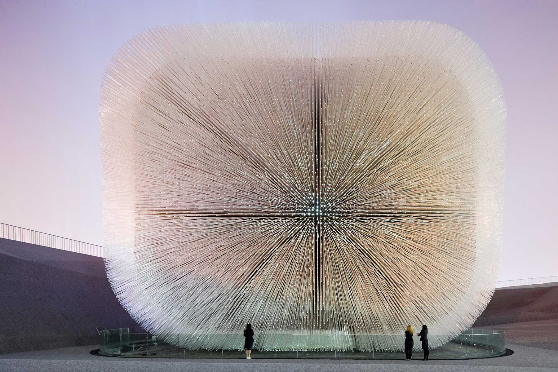 The UK pavilion at Expo 2010, colloquially known as the Seed Cathedral, was a sculpture structure built by a nine-member conglomeration of British business and government resources directed by designer Thomas Heatherwick. The Seed Cathedral is 20 meters in height, formed from 60,000 slender transparent fibre optic rods, each 7.5 metres long and each encasing one or more seeds at its tip. In its unique biomimetic design, during the day, they draw daylight inwards to illuminate the interior. At night, light sources inside each rod allow the whole structure to glow. As the wind moves past, the building and its optic “hairs” gently move to create a dynamic effect.